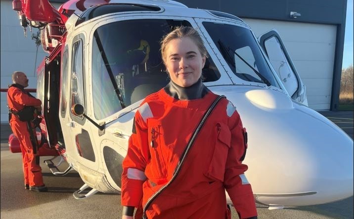 Elvira står framför en av Sjöfartsverkets helikoptrar