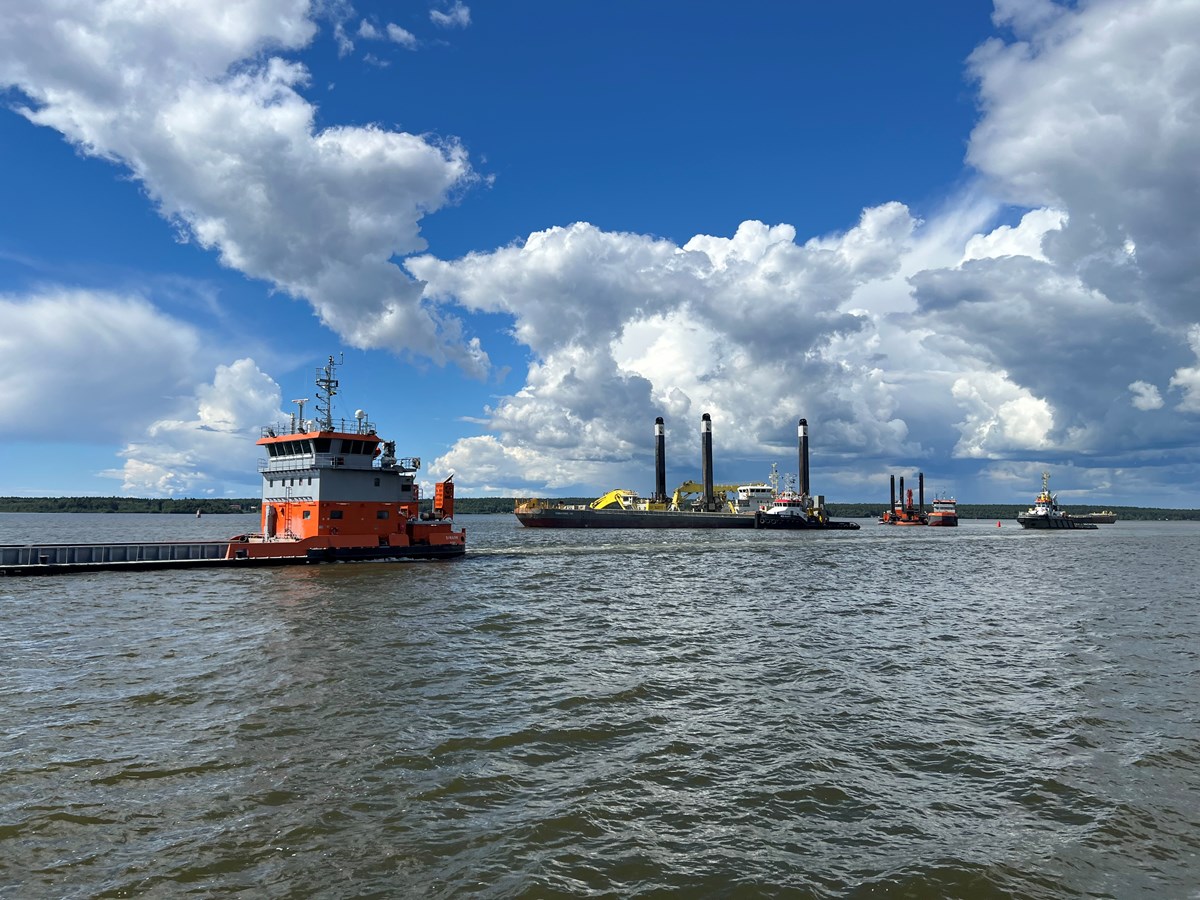 Himmel med tjocka moln, vatten, mudderverk som arbetar