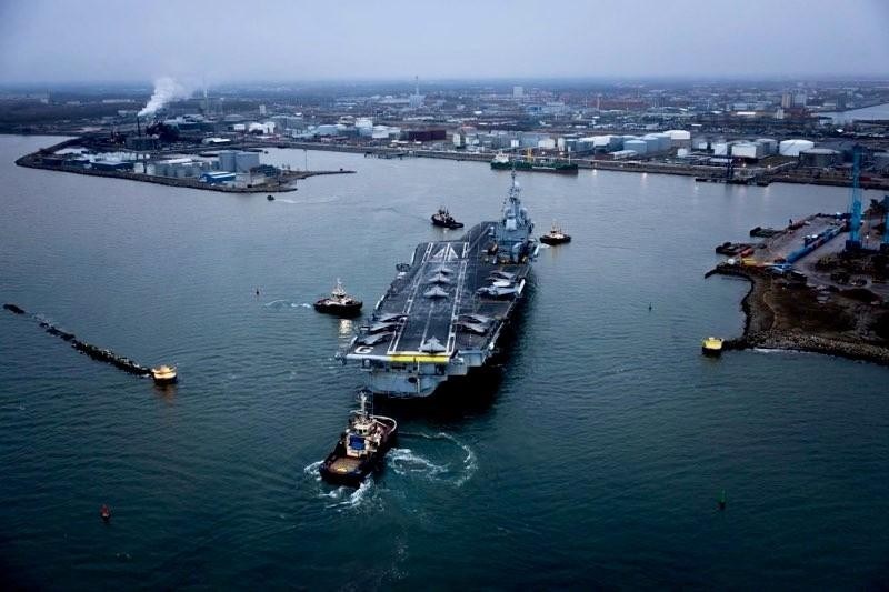 drönarbild på hangarfartyg på väg in till hamn