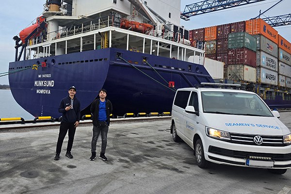 Mini van in front of a moored ship