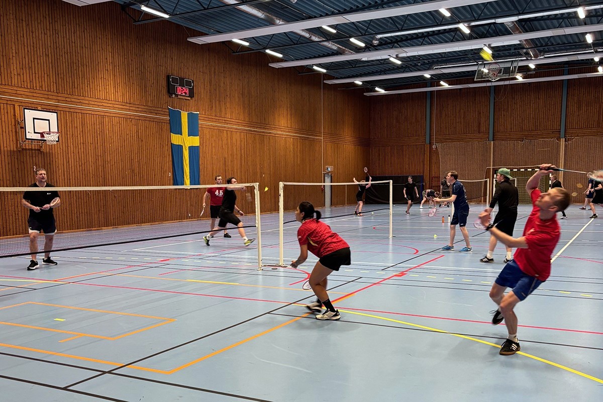 Flera deltagare spelar badminton i en sporthall